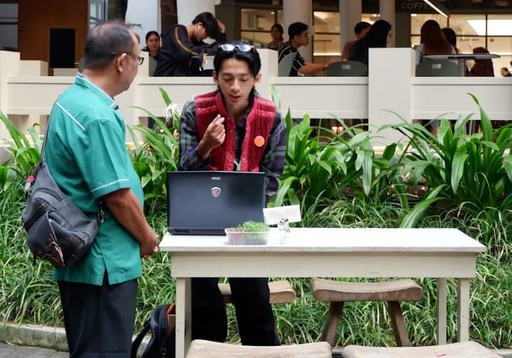 Edukator Ngadaur menjelaskan proses pengolahan kepada pengunjung di meja edukasi