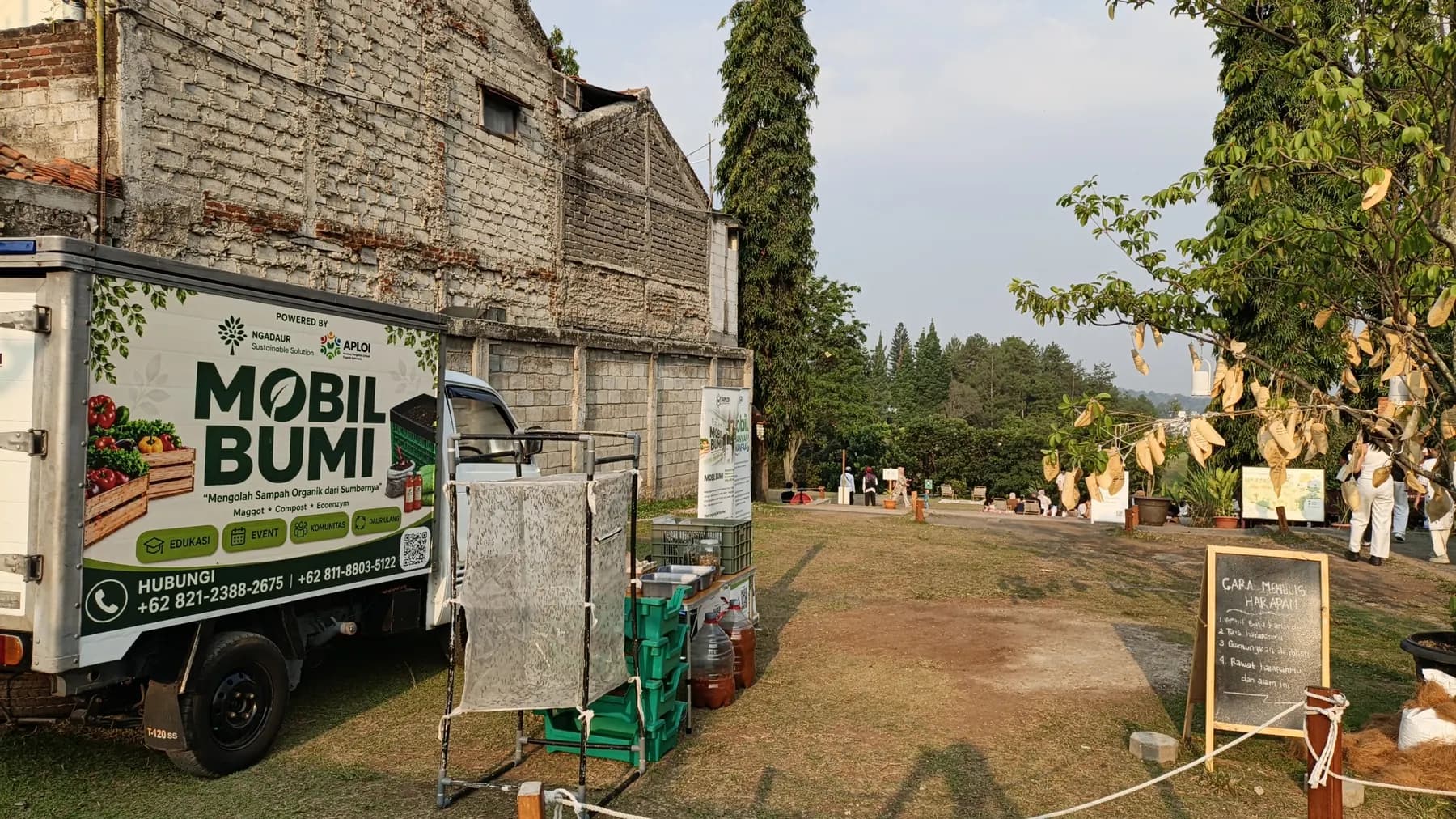 Mobil Bumi terparkir di lokasi event dengan booth dan banner Ngadaur, Agustus 2026
